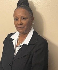 karen kelly is a person with a short, dark-brown bob, wearing a multi-colored girl scout scarf and navy blue jacket