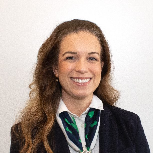 lauren watterhead is a person with long light brown hair wearing a multi-colored girl scout scarf and navy blue jacket