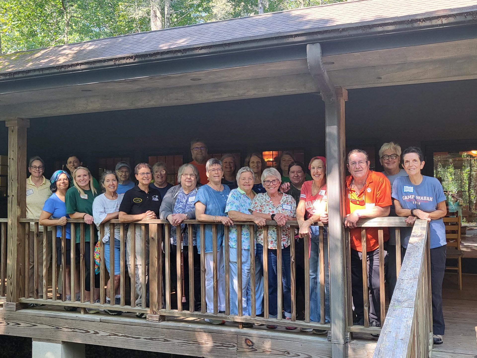  Members of Friends of Camp WaBak gather together and pose on a porch at Camp WaBak. 