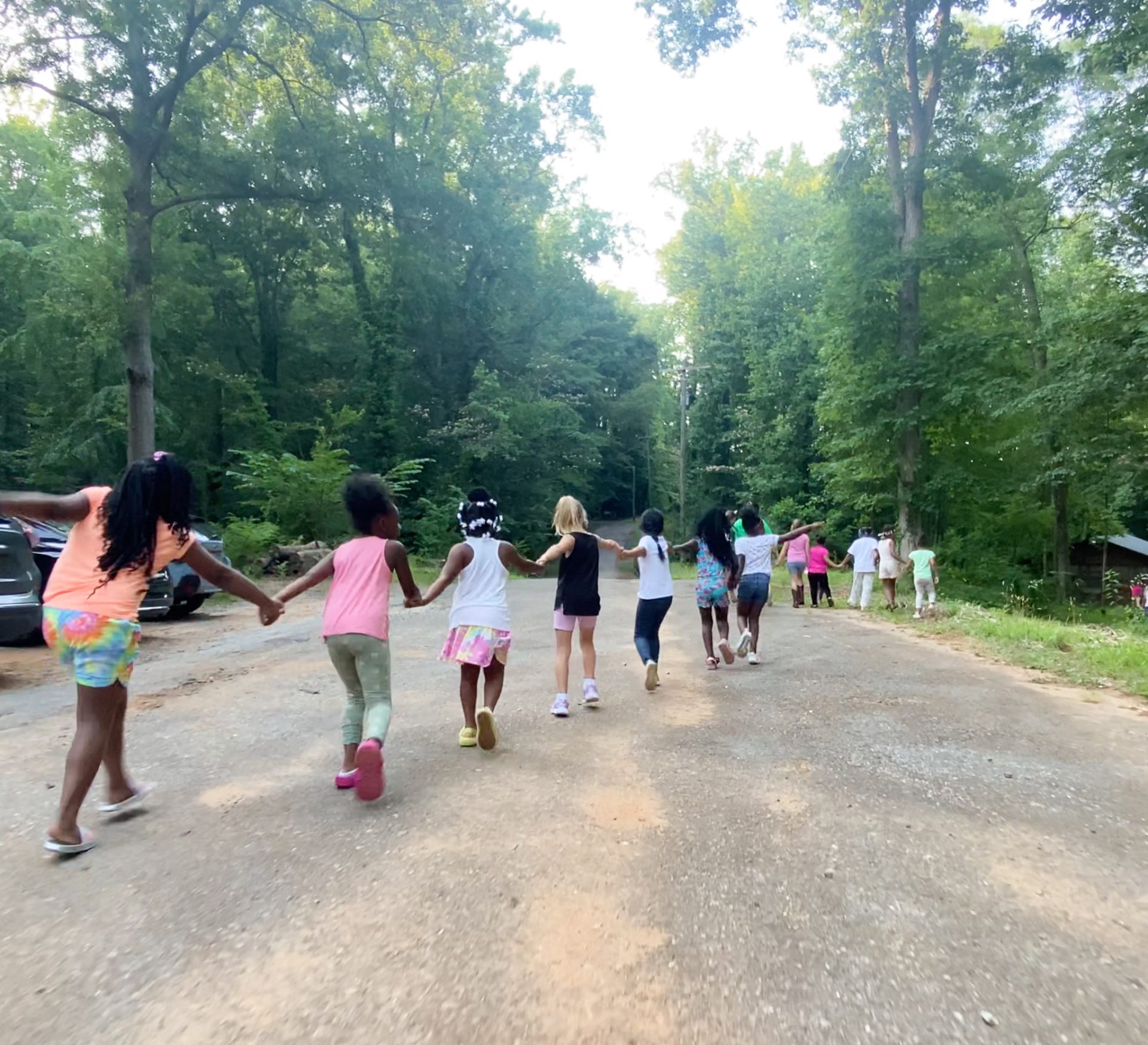  Girl Scouts link hands and cross a road at Camp Mary Elizabeth. 