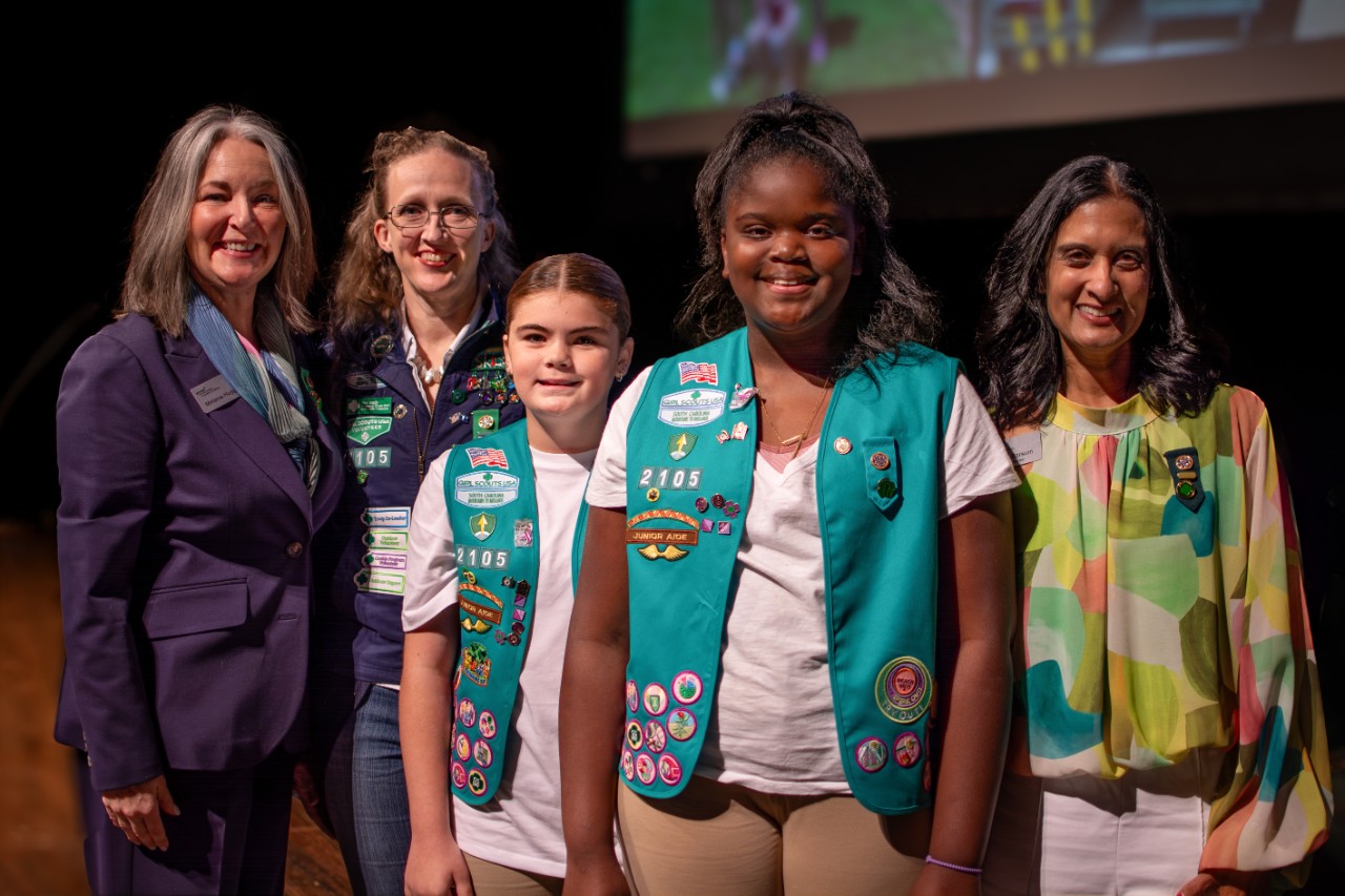 Two Bronze Award Girl Scouts pose with troop leader and council representatives