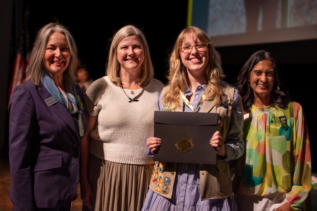 CEO Melanie and Board Chair Kavita pose with a Gold Award Girl Scout
