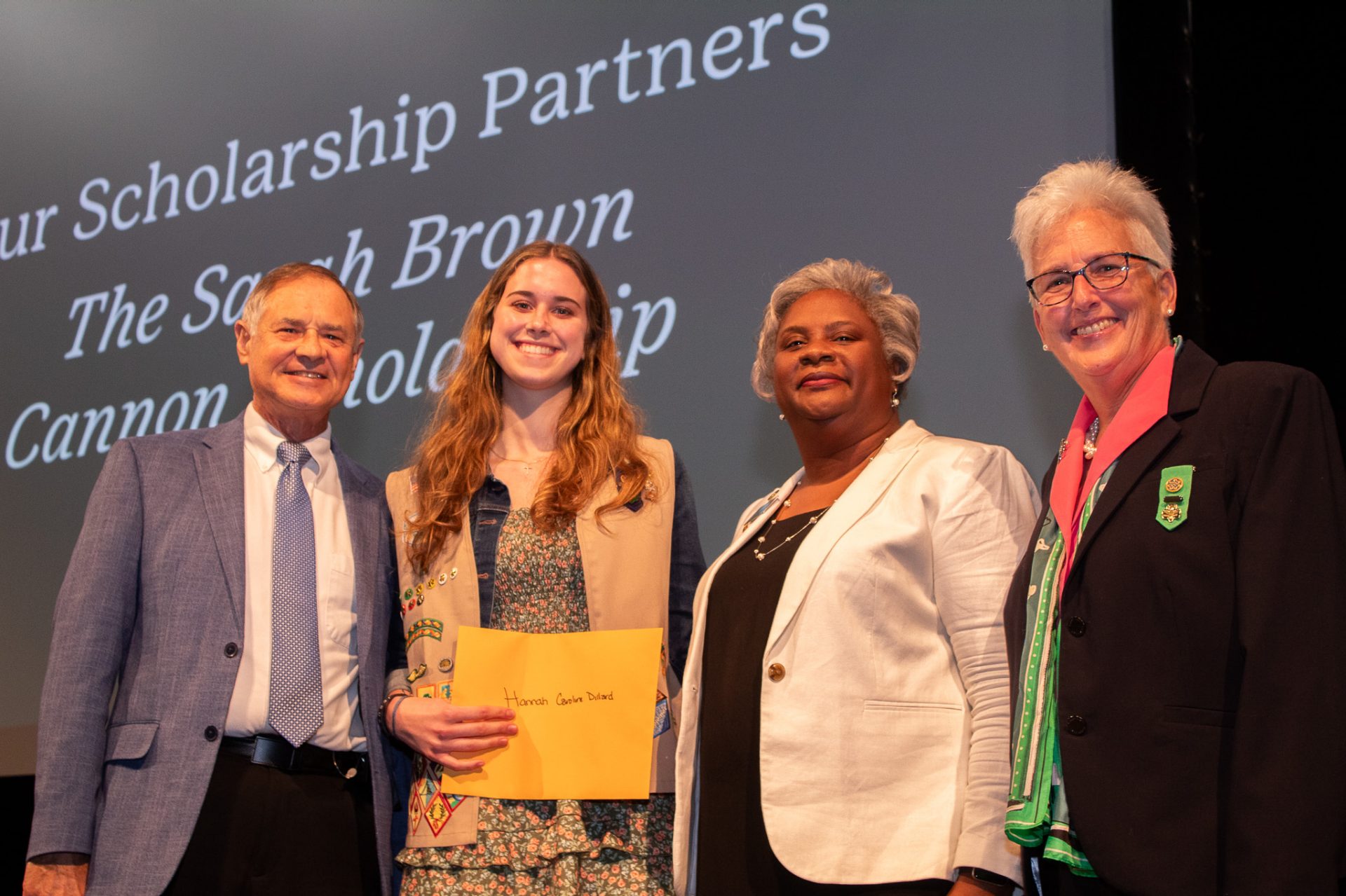a girl scout poses onstage after earing the Sarah Brown Cannon Scholarship