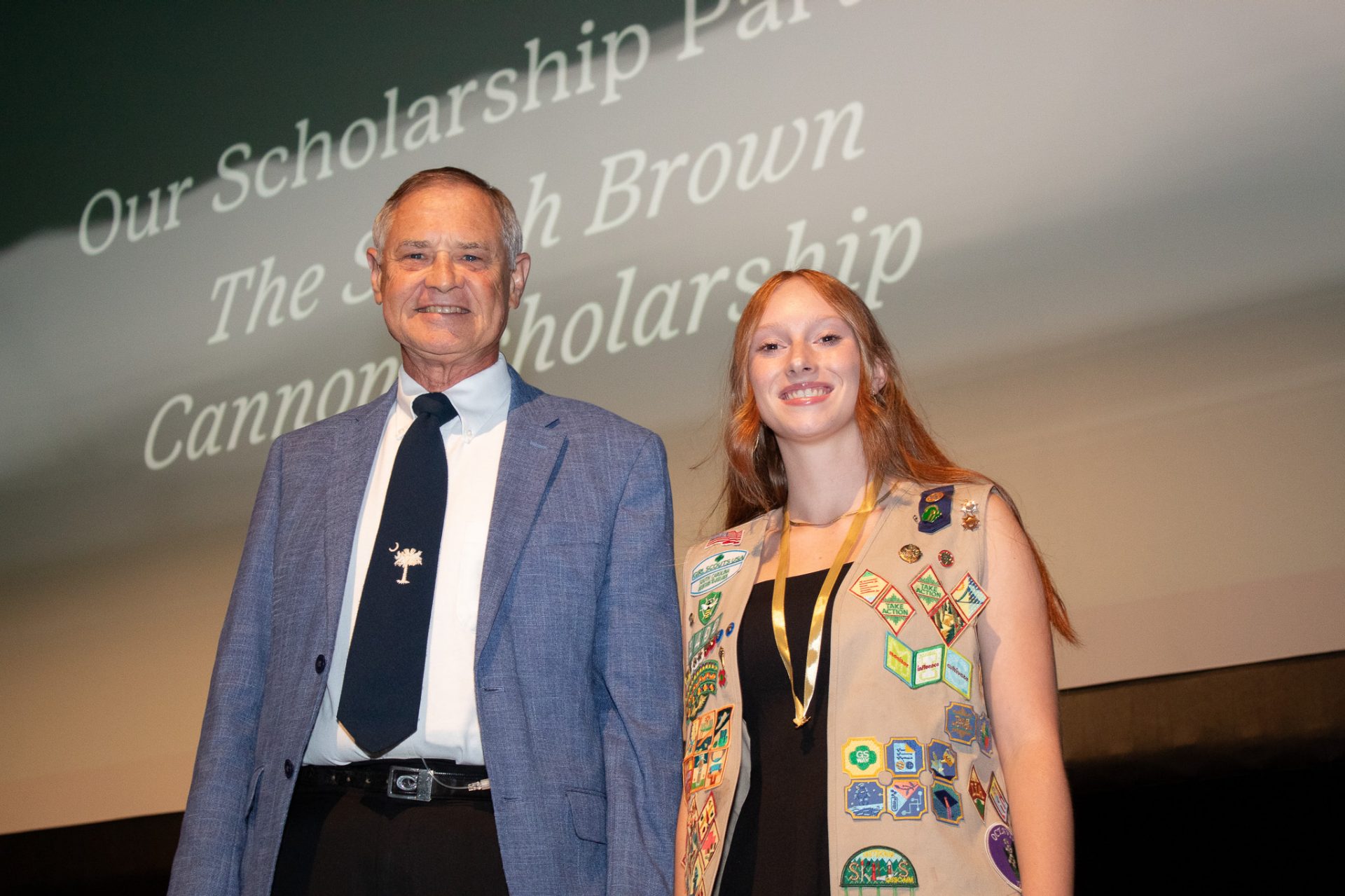 a girl scout poses onstage after earing the Sarah Brown Cannon Scholarship