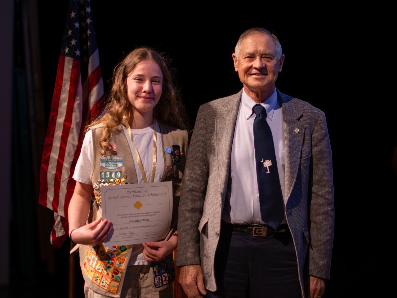 a girl scout poses onstage after earing the Sarah Brown Cannon Scholarship