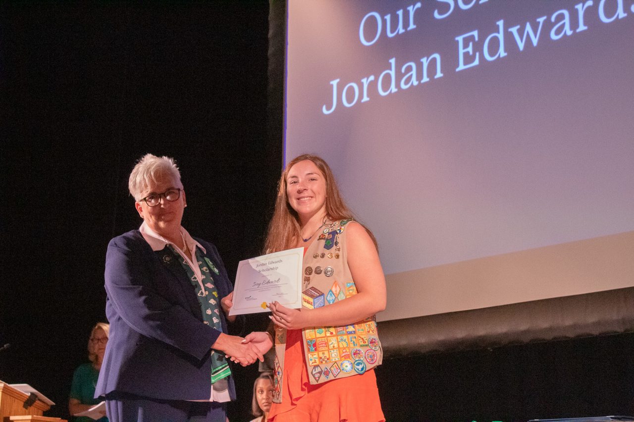former CEO Lora shakes hands with the Jordan/Edwards Scholarship recipient
