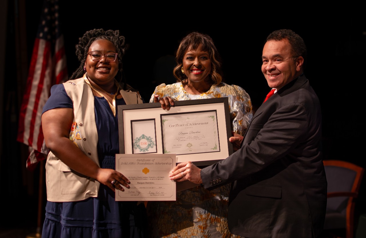 gold award girl scout poses with scholarship representative