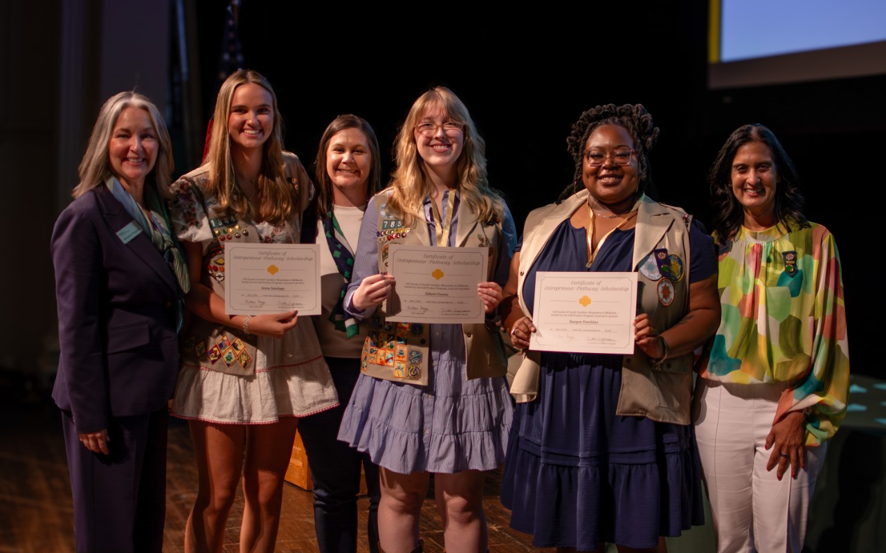 Three Gold Award Girl Scouts pose with their scholarships at Highest Awards Ceremony
